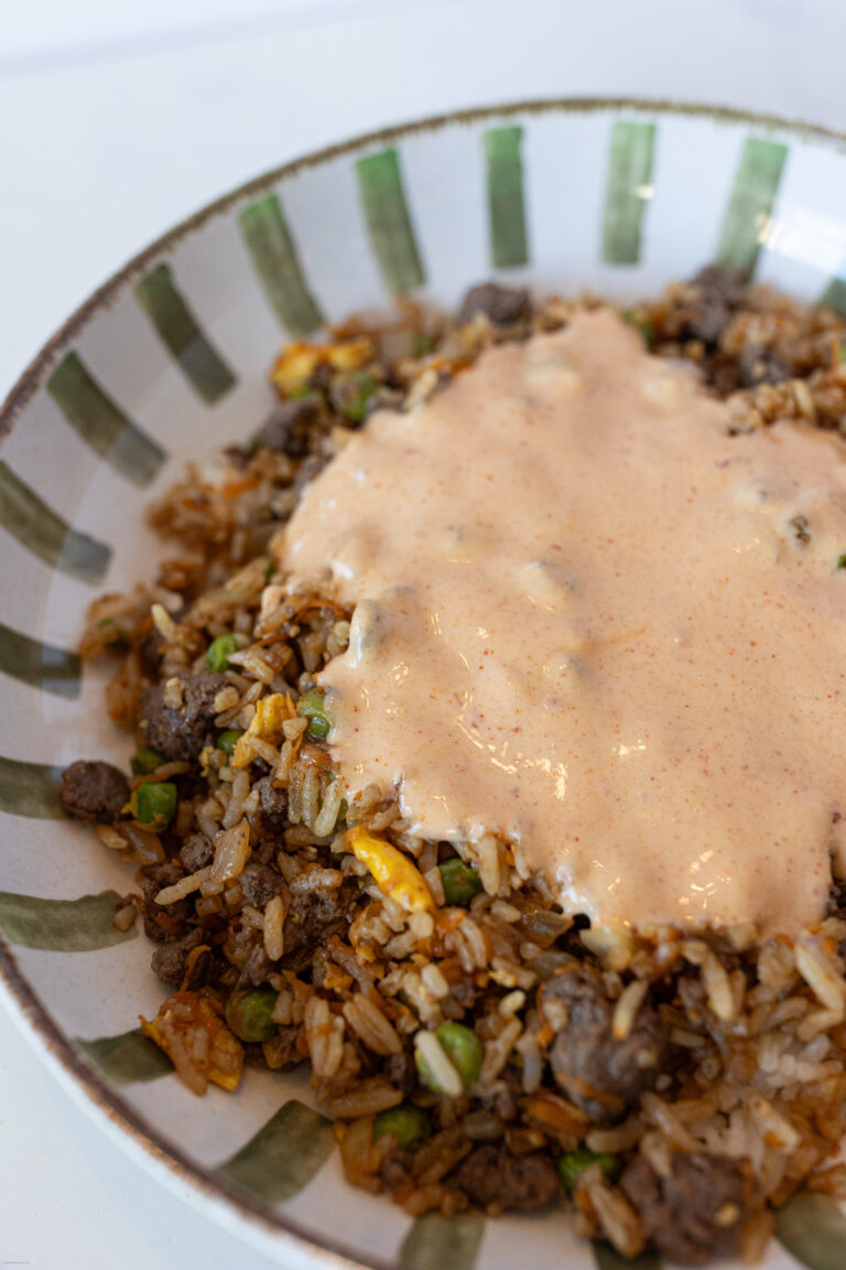 Beef fried rice in a bowl with yum yum sauce on top