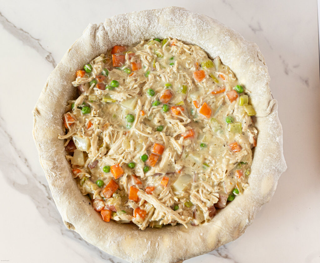 chicken pot pie filling in an unbaked pie crust